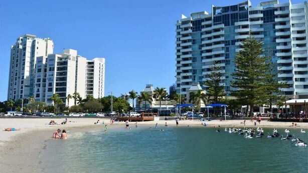 A beachfront hotel with multiple high-rise buildings, a sandy beach, and a clear blue sky. - Broadwater Waterfront Balcony near Sea World (Labrador)
