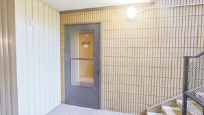 A door with a number plate, a tiled wall, and a staircase with a metal railing. - Adorable 1-bedroom condo 109 - Lava Hot Springs Resort a Romantic Getaway (Lava Hot Springs)