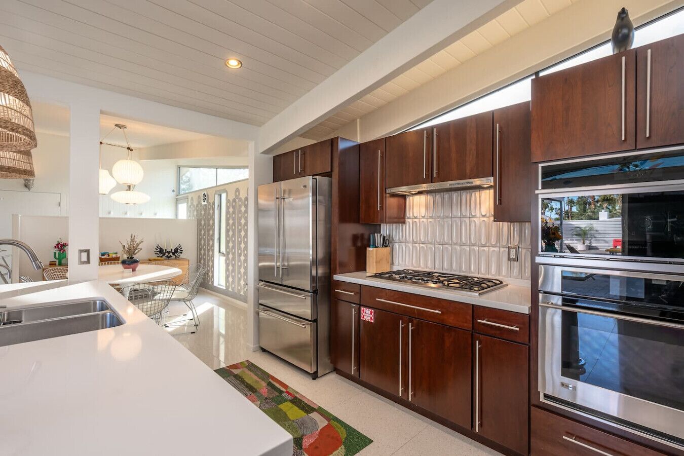 A modern kitchen with stainless steel appliances, wooden cabinets, and a large island.