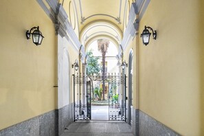 A corridor with a wrought iron gate, arched ceilings, and wall-mounted lanterns. - Easylife - Milano - Tadino 6 - Porta Venezia (Milano)