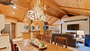 A spacious wooden interior with a dining area, kitchen, and living space. - Risa Cabin: Hot Tub, Private Lake (Bend)