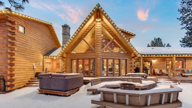 A log cabin with a large deck, outdoor hot tubs, and a covered seating area. - Risa Cabin: Hot Tub, Private Lake (Bend)