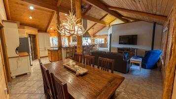 A spacious wooden interior with a dining area, kitchen, and living space.