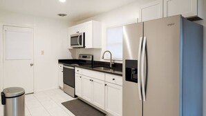A modern kitchen with stainless steel appliances, white cabinetry, and a built-in microwave. - Waterfront Escape w/ Private Pier • Minutes to BWI (Glen Burnie)