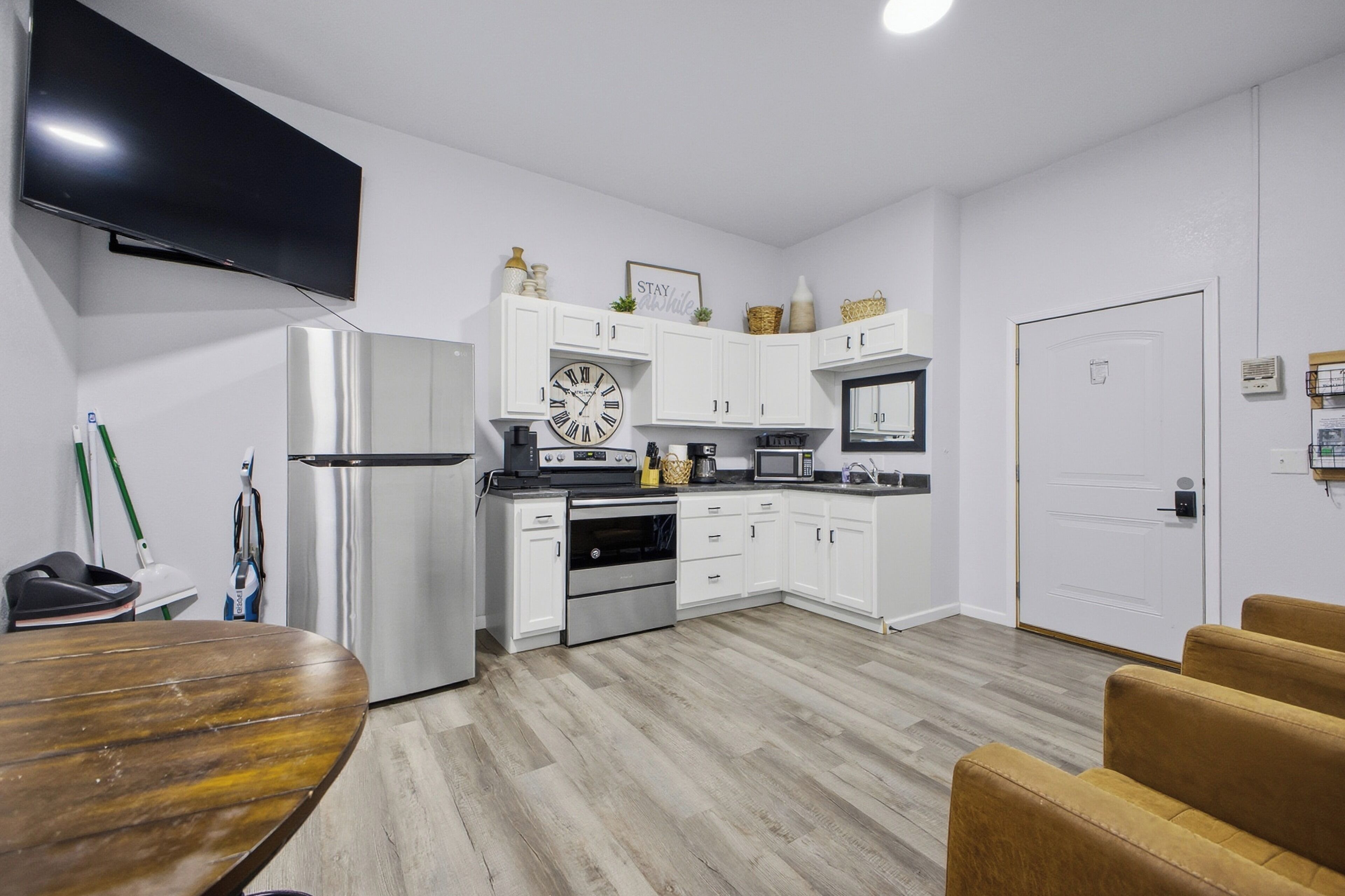 Bright kitchenette with stainless appliances, TV, and dining nook