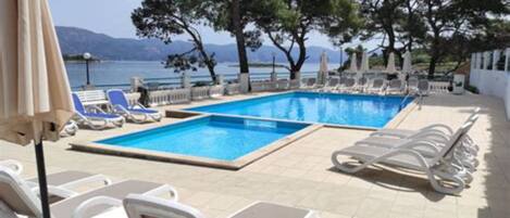 Piscine extérieure en saison, chaises longues