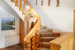 Eine Holztreppe mit einem außergewöhnlichen Design, ein Heizkörper und ein gerahmtes Bild an der Wand.