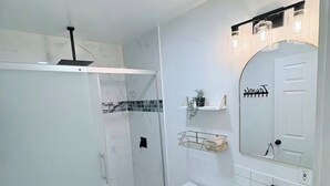 A modern bathroom with a shower, toilet, and vanity.