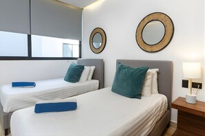 A hotel room with two beds, a nightstand with a lamp, and two wall-mounted mirrors. - Modern Apartment Near Fifth Avenue (Playa del Carmen)