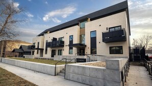 A modern building with a flat roof, large windows, and a concrete staircase leading to the entrance. - Wildcat Speakeasy | K-State Vibes + Prime Location (Manhattan)