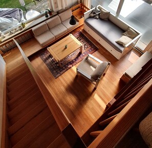 A modern, compact living space with a sofa, a small table, and a chair. - Sea period vacation apartment (Neustadt in Holstein)