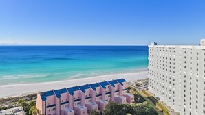 Un hotel frente al mar con vista despejada al océano y una playa de arena.