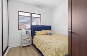 A bedroom with a bed, a window with blinds, a shelf, and a door. - Family Beach Escape • Private Pool • Ocean View • Sleeps 8 (De Hatillo)