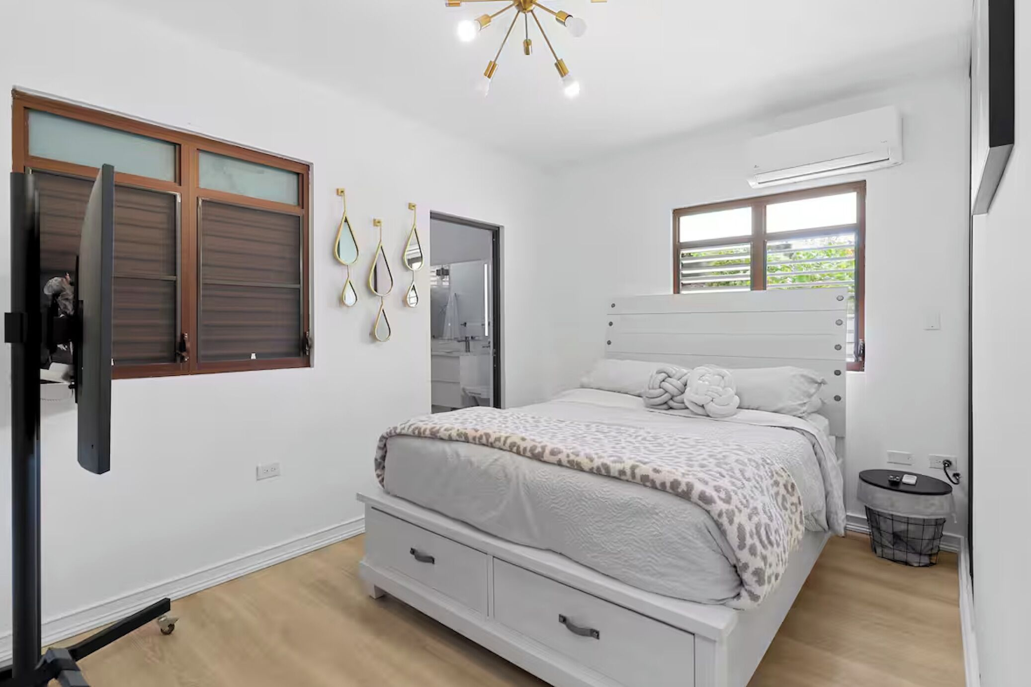 A bedroom with a bed, a wardrobe, a mirror, and a window.