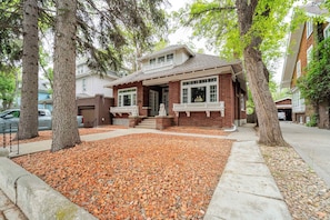 A brick house with a front porch, a garage, and a driveway.