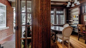 Un coin repas avec une table et des chaises en bois, un mur en briques et un sapin de Noël.