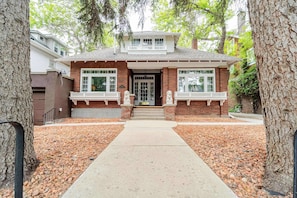 A two-story house with a front porch, brick exterior, and a driveway leading to the entrance.
