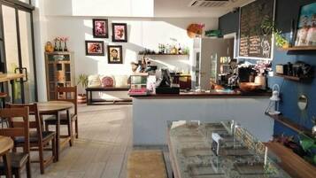 A café with wooden furniture, a counter with a coffee machine, and various decorations on the walls.