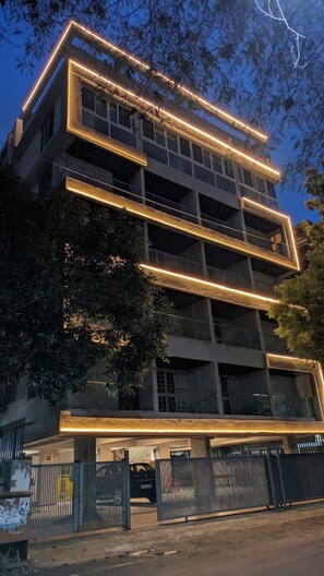 Ein mehrgeschossiges Gebäude mit modernem architektonischen Design, das eine Reihe von Balkonen und großen Fenstern aufweist.