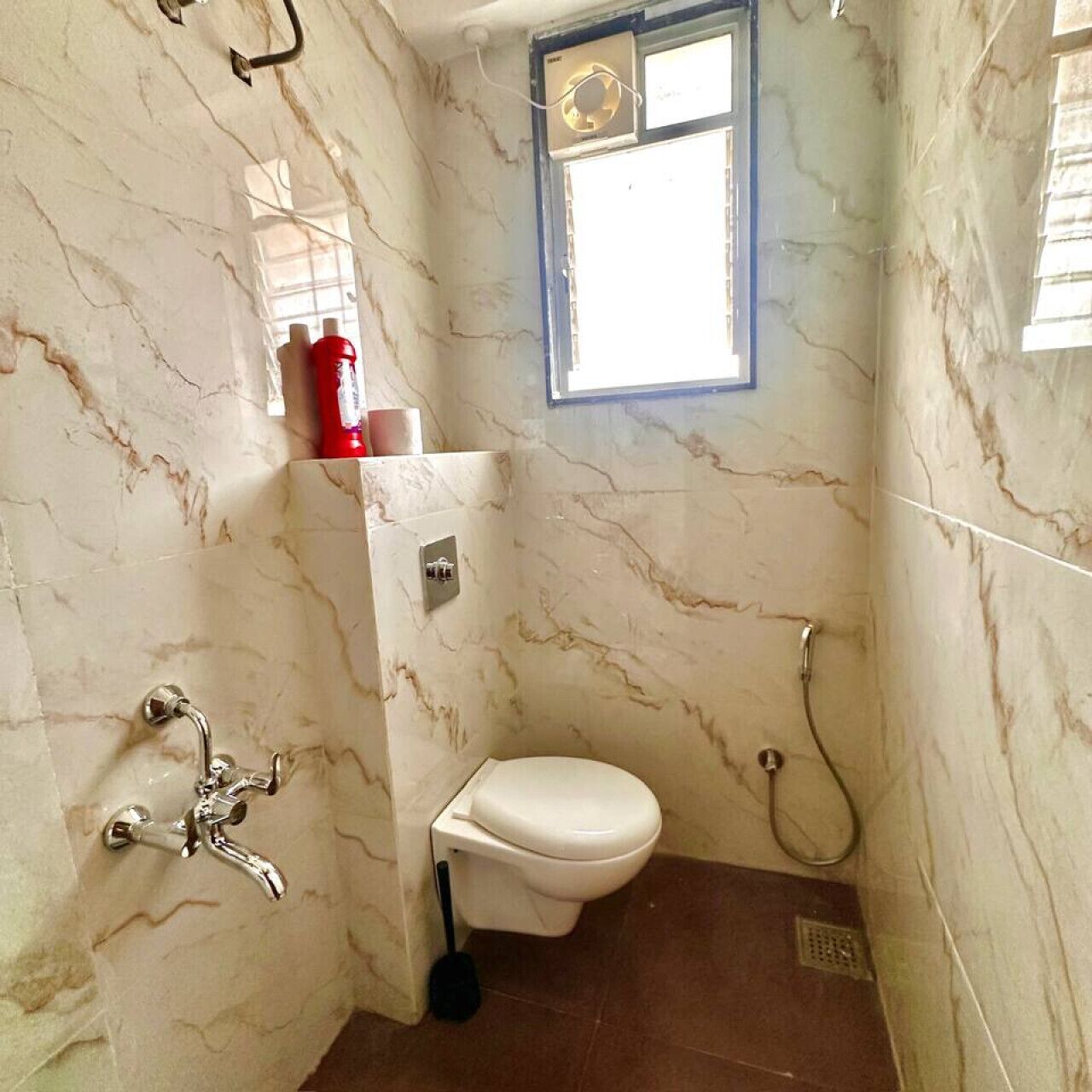 Un baño con inodoro, ducha y ventana.