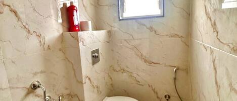 Un baño con inodoro, ducha y ventana.