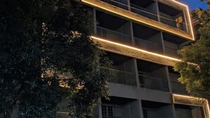 A multi-story building with a modern architectural design, featuring a series of balconies and large windows. - Crane House: Spacious 2BHK AC Flat by Bleisure (Pimpri-Chinchwad)