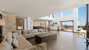 A spacious living area with a sectional sofa, a coffee table, and a stone accent wall.