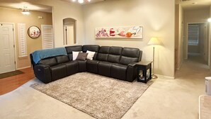 A living room with a sectional sofa, a ceiling fan, a rug, a lamp, and artwork on the wall. - Full 3-Bdrm home, EV charger & space to park anything.  (Madera)