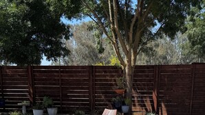 A patio with a fire pit, two wooden chairs, and a table. - Full 3-Bdrm home, EV charger & space to park anything.  (Madera)