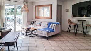 A living room with a sofa, a coffee table, a dining table with chairs, and a kitchen area with a bar stool. - Amazing home in Collias (Collias)