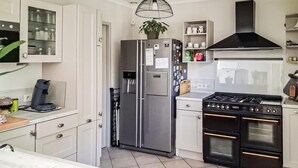 A modern kitchen with a built-in refrigerator, a stove, and a sink. - Amazing home in Collias (Collias)