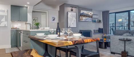 A modern apartment with a dining area, kitchen, and living space.