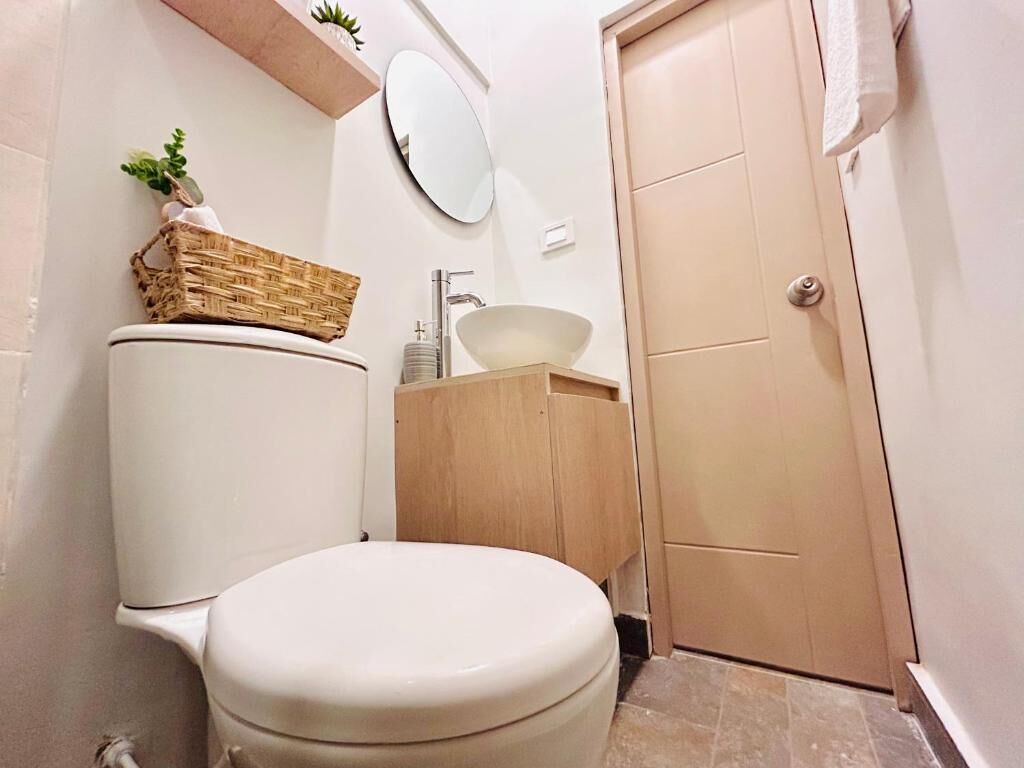 Ein Badezimmer mit Toilette, Waschbecken und einer Tür.