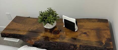 A wooden table with a plant and a white object on it.