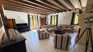 A spacious living room with a piano, sofas, a coffee table, and a tripod. - Le Tuquet de Saint Chamassy, private swimming pool (ST CHAMASSY)