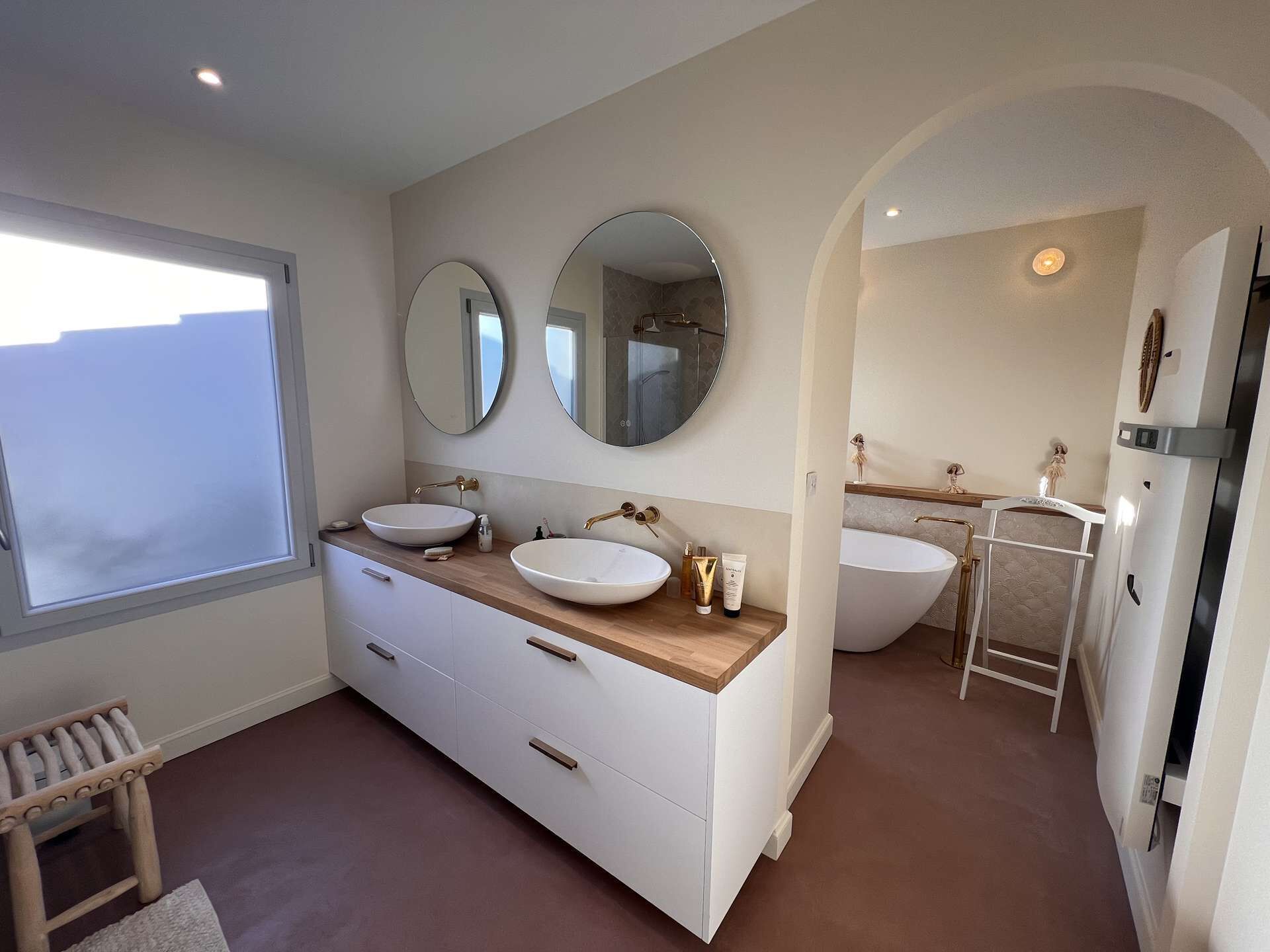 Ein modernes Badezimmer mit zwei Waschbecken, einem großen Spiegel und einer Badewanne.