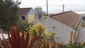 A residential area with a house featuring a tiled roof, a concrete chimney, and a small window. - Refuge - "Vivenda Chã" (Ribeira Funda)
