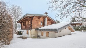 A wooden cabin with a sloped roof and a snow-covered ground. - Chalet du Grand Air - Welkeys (Megève)