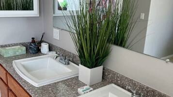 A bathroom with two white sinks, a mirror, and a shower curtain with a floral pattern.
