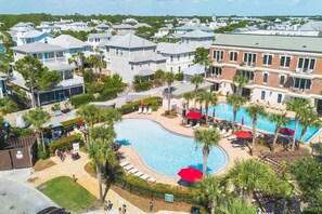 A residential area with a swimming pool surrounded by palm trees and lounge chairs. - Golden Hour Seacrest by Stay on 30a (Seacrest Beach)