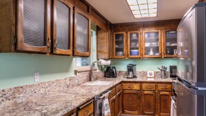 A kitchen with wooden cabinets, granite countertops, a stainless steel refrigerator, and a built-in oven. - The Rose House: Spacious Retreat w/ Fire Pit Deck/ near expo & Airport/Sleeps 8 (Central Point)
