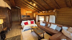 Ein gemütliches Blockhaus-Interieur mit Wohnbereich, Essbereich und Küche.