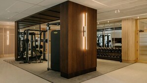 A modern gym with weightlifting equipment, a wooden pillar, and a glass wall. - Canvas Wembley Arthur House (Wembley)