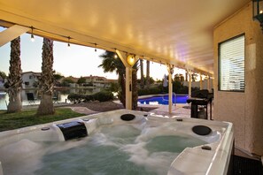 Ein Whirlpoolbereich mit Blick auf einen Pool und Palmen.