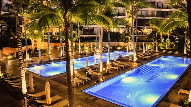 A pool area with multiple swimming pools, lounge chairs, and palm trees. - Marina Vallarta Beautiful apartment with jacuzzi (Puerto Vallarta)