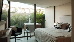 A modern hotel room with a large bed, a desk, and a view of the outdoors. - Marina Vallarta Beautiful apartment with jacuzzi (Puerto Vallarta)