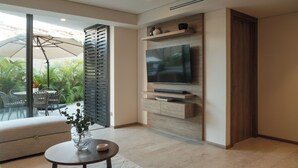 A modern living room with a large TV, a sofa, and a dining area with chairs. - Marina Vallarta Beautiful apartment with jacuzzi (Puerto Vallarta)