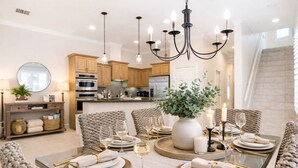 A modern dining room with a glass table set for six, surrounded by woven chairs.