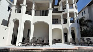 A large, multi-story house with a swimming pool in the foreground.
