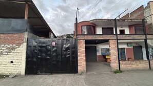 A gated entrance to a building with a brick facade and a covered area.